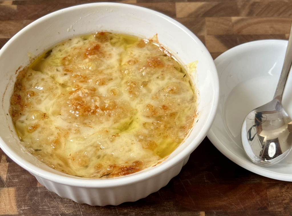 Homemade keto onion soup topped with bubbly broiled cheese, ready to serve