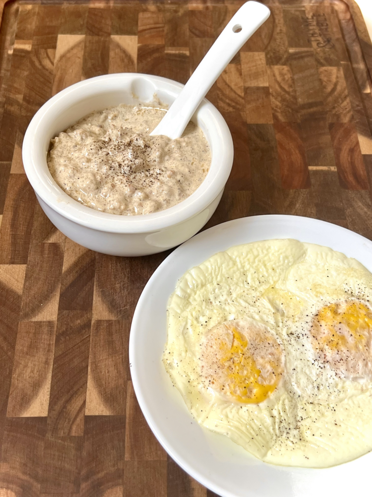 Creamy keto breakfast sausage gravy served in a white bowl with eggs