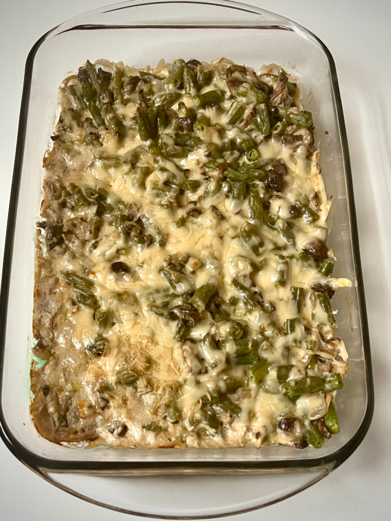 Creamy keto green bean casserole topped with melted parmesan cheese in a baking dish
