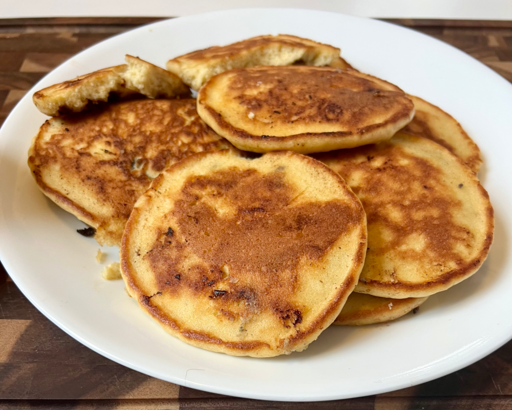 Fluffy keto almond flour pancakes cooked until golden brown and stacked on a white plate