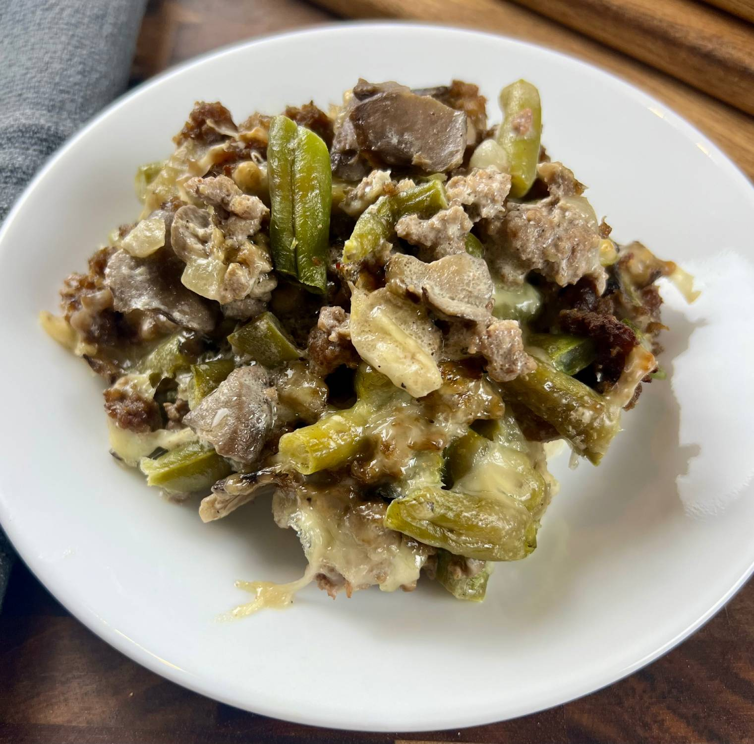 Keto beef and green bean casserole baked with creamy cheese sauce in a casserole dish